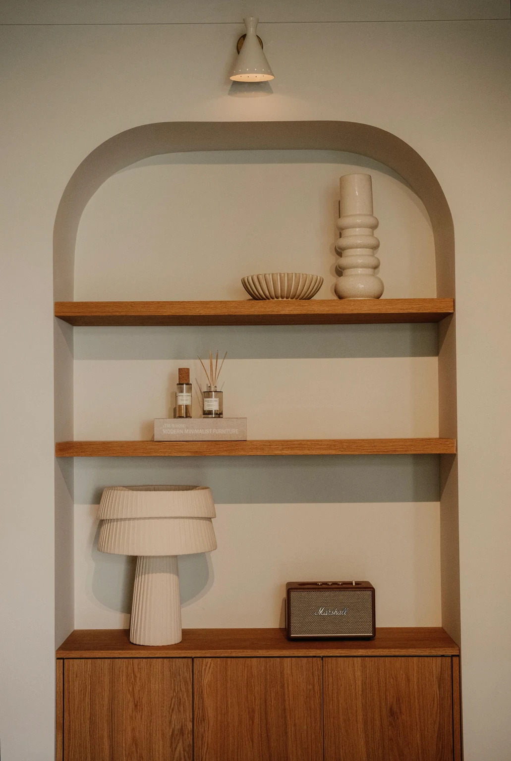 Gebogen maatwerknis met eiken planken, keramiek en warme verlichting.