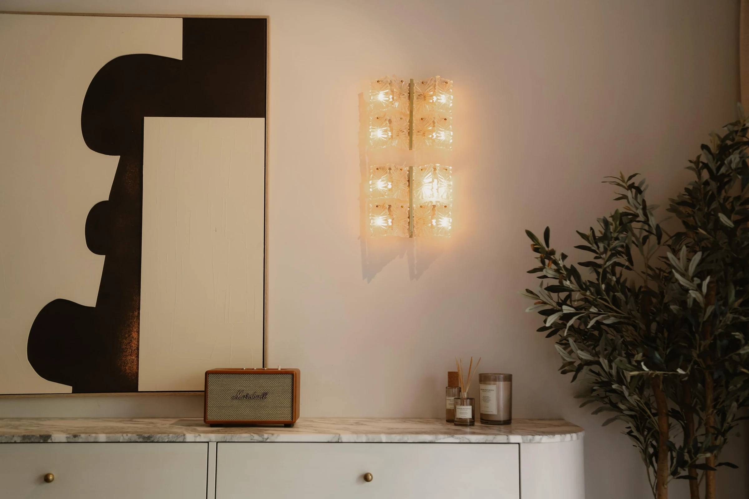 Marmeren kast, sculpturale kunst en sfeervolle wandverlichting.